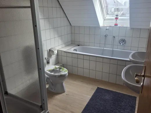 Badezimmer mit Badewanne und Dusche